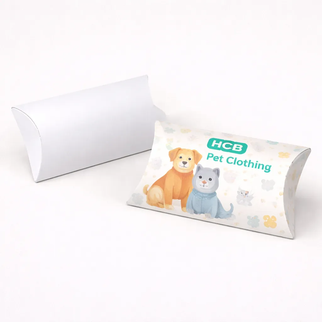 Two pillow-shaped packaging boxes, one plain white and one printed with teal waves and HCB logo. class=